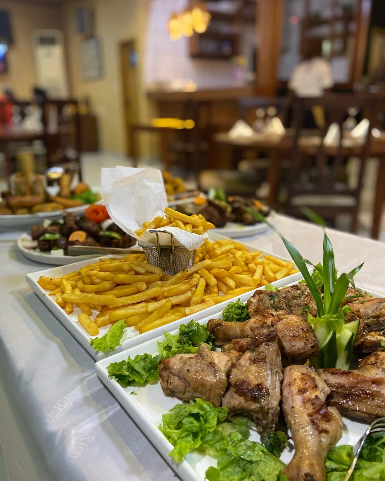 De grands plats de poulet grillé et de frites à partager