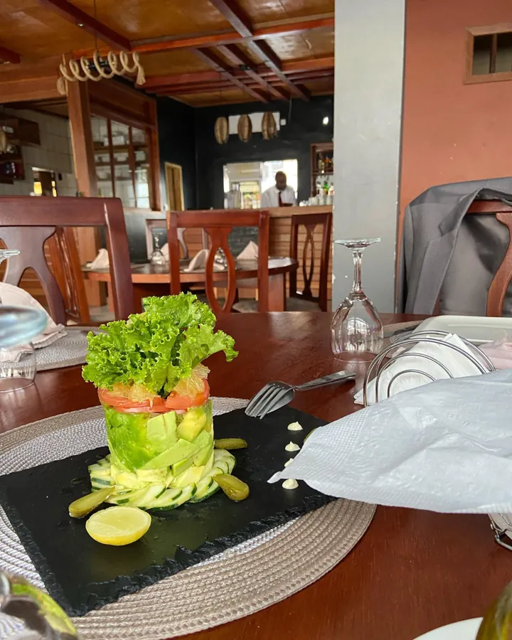 Une entrée d’avocat et de tomate dressée sur une ardoise noire