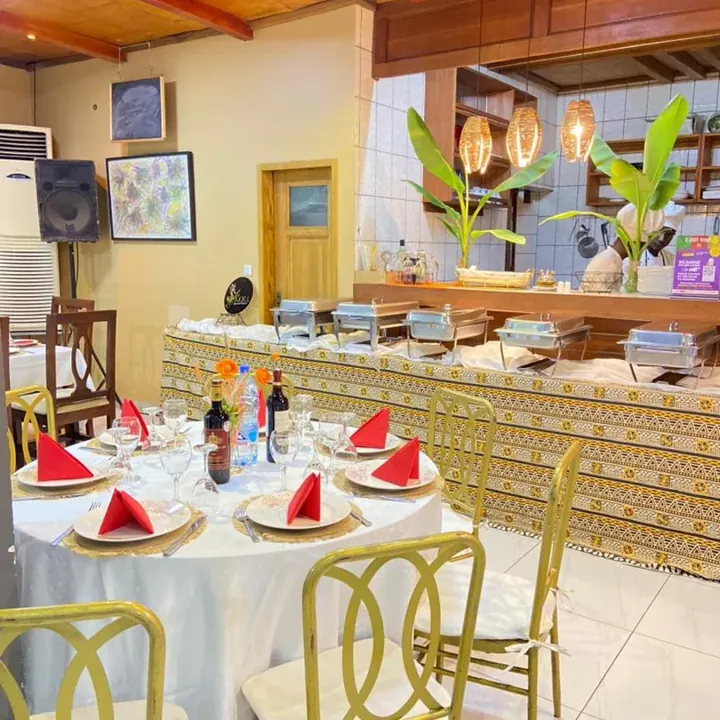 Une table de fête avec serviettes rouges et chaises dorées chez Koll