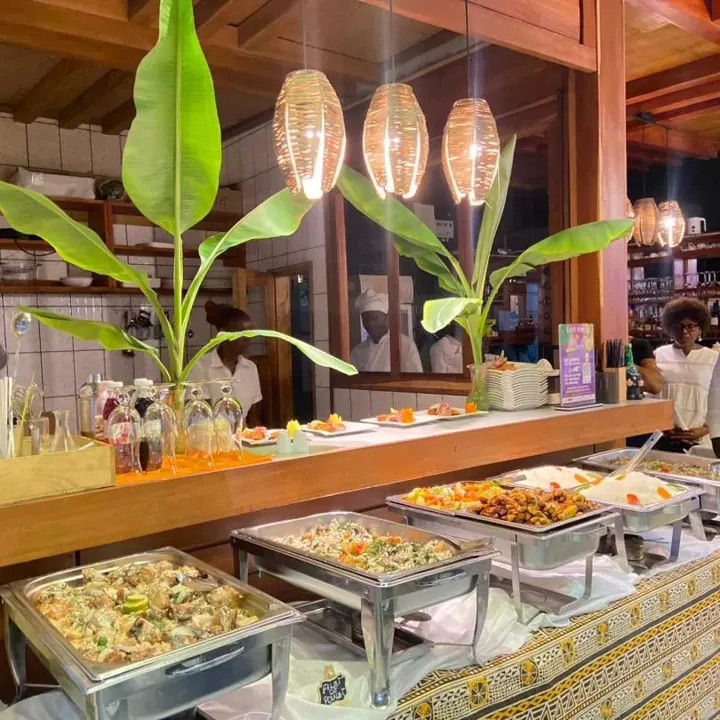 Le buffet de Chez Koll, décoré de feuilles vertes sous les suspensions chaleureuses